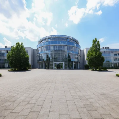 Das Bild zeigt den Haupteingang des Kerpen Techparks mit runder Glasfassade und umliegenden modernen Büroeinheiten.
