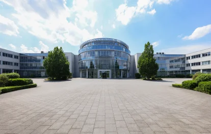 Das Bild zeigt den Haupteingang des Kerpen Techparks mit runder Glasfassade und umliegenden modernen Büroeinheiten.