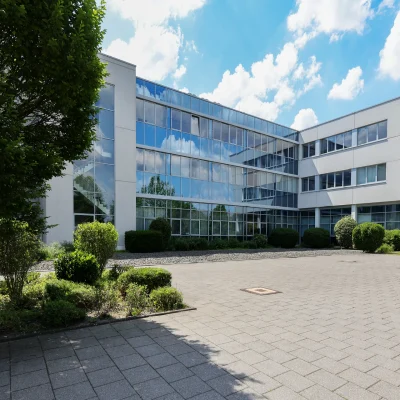 Das Bild zeigt die Außenansicht eines Bürogebäudes im Kerpen Techpark mit moderner Glasfassade und gepflegter Grünanlage.