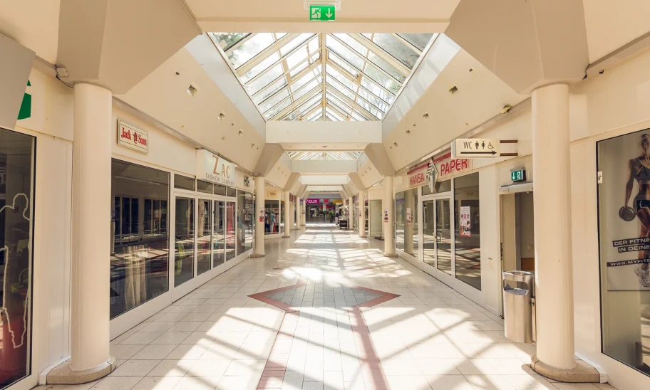 Das Bild zeigt eine lichtdurchflutete Einkaufspassage im Hansa-Centrum Krefeld mit leerstehenden Ladengeschäften und großem Glasdach.