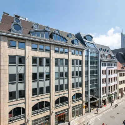 Das Bild zeigt den Eingang zur Strohsack-Passage in Leipzig mit Glasdach, Schaufenstern und Zugängen zu verschiedenen Ladengeschäften im Stadtzentrum.