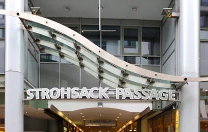 Das Bild zeigt die Außenansicht eines modernen Bürogebäudes mit Glasfassade im Leipziger Stadtzentrum, Teil der Strohsack-Passage mit Zugang zu Läden und Büros.