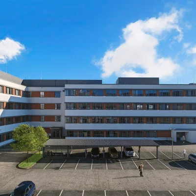 Abgebildet ist die Rückansicht eines Bürogebäudes in Frankfurt mit Parkplätzen und überdachten Stellplätzen.