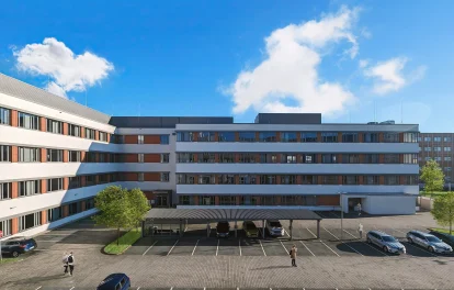 Abgebildet ist die Rückansicht eines Bürogebäudes in Frankfurt mit Parkplätzen und überdachten Stellplätzen.