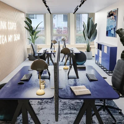 Modern gestalteter Büroraum mit Designer-Schreibtischen, Teppichboden und Pflanzen.