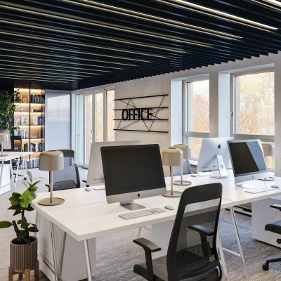 Ein modernes Open-Space-Büro in Nürnberg mit Arbeitsplätzen, iMacs und dekorativen Deckenelementen.