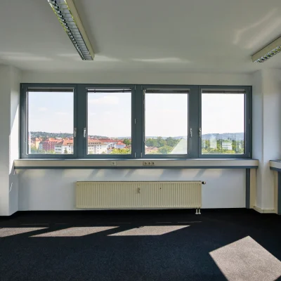 Helles Einzelbüro mit großem Fensterbereich und Blick auf die Stadt Würzburg.