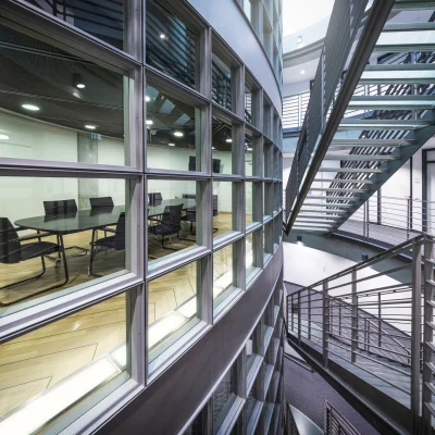 Ein moderner Konferenzraum in einem Frankfurter Bürogebäude mit bodentiefer Fensterfront und umliegenden Sicherheitstreppen.