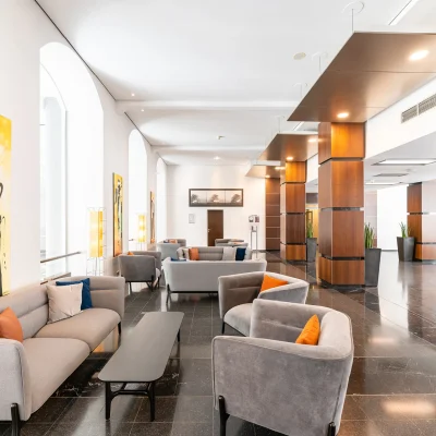 Das Bild zeigt eine moderne Lounge mit Sofas und Sesseln im Empfangsbereich eines Bürogebäudes.