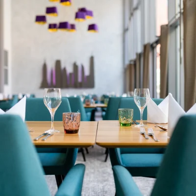 Das Bild zeigt einen gedeckten Tisch im modernen Bürorestaurant mit großen Fensterfronten.