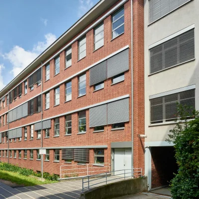 Rückansicht des Frankencampus Nürnberg mit barrierefreiem Zugang und Sonnenschutz an den Fenstern.