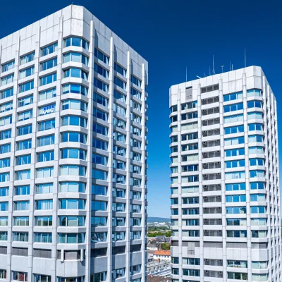 Nahaufnahme der Bonifaziustürme in Mainz mit moderner Glasfassade und klarem Himmel im Hintergrund.