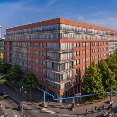 Moderne Büroimmobilie in Berlin mit roter Backsteinfassade und blauen Himmel.