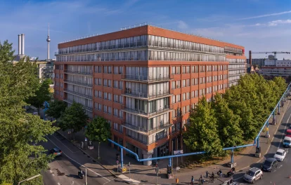 Moderne Büroimmobilie in Berlin mit roter Backsteinfassade und blauen Himmel.