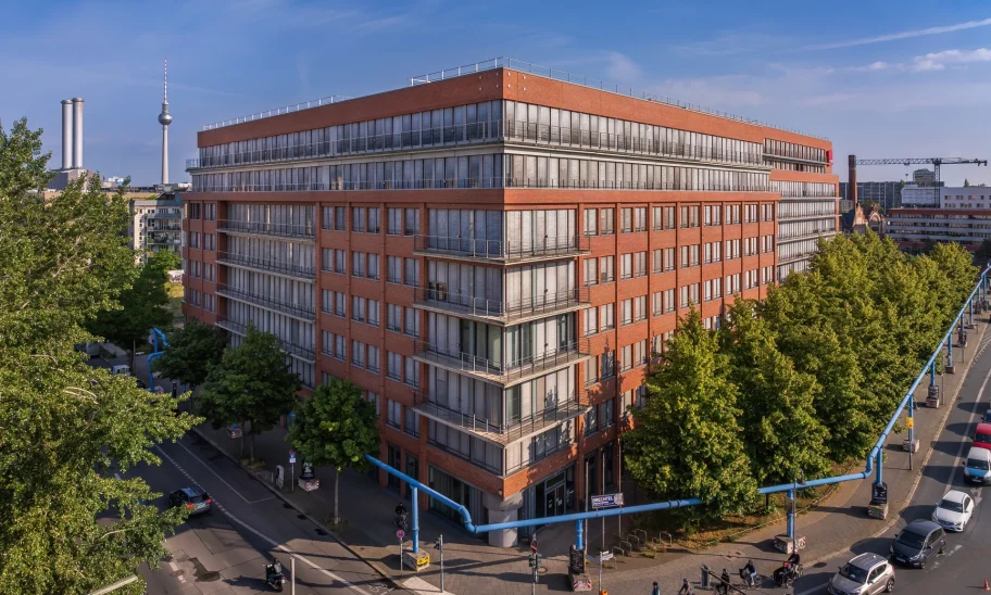 Moderne Büroimmobilie in Berlin mit roter Backsteinfassade und blauen Himmel.