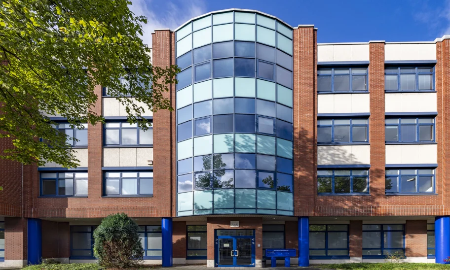 Zentrale Fassadenansicht eines Bürogebäudes an der Erkrather Straße in Düsseldorf mit verglastem Eingangsbereich, symmetrischer Architektur und blau akzentuierten Stützen.
