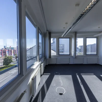 Leere Bürofläche im Objekt Horizont III in Stuttgart mit großzügiger Fensterfront, viel Tageslichteinfall, dunklem Bodenbelag und freiem Blick auf die Umgebung