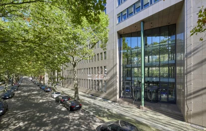 Straßenansicht eines Bürogebäudes in der Soorstraße in Berlin mit repräsentativem Eingangsbereich, baumbestandener Allee und parkenden Fahrzeugen entlang der Straße.