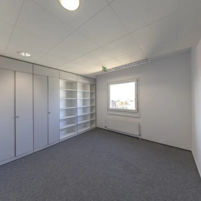 Helles Einzelbüro im Businesspark Welfenplatz Hannover mit Einbauschränken, Regalwand und großem Fenster.