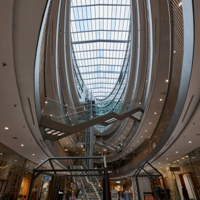 Atrium des Düwell Düsseldorf mit offenen Galerien, Glasdecken und modernen Beleuchtungselementen.