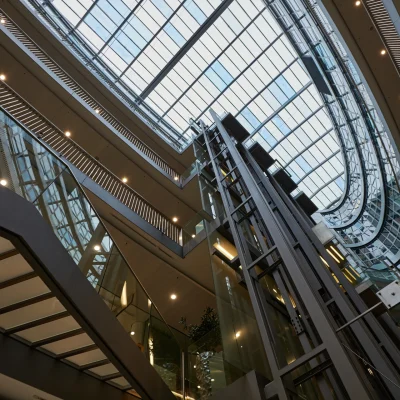 Aufzugsanlage und Glasfassade im zentralen Atrium des Düwell in Düsseldorf mit moderner Innenarchitektur.