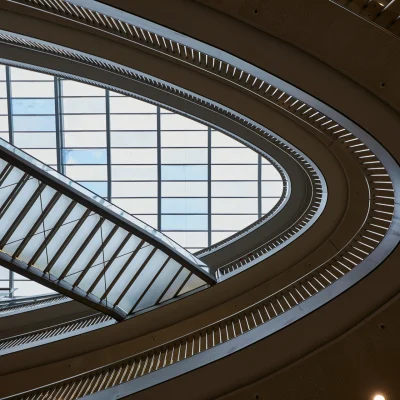 Blick auf das Glasdach und die geschwungene Treppenarchitektur im Atrium des Düwell in Düsseldorf.