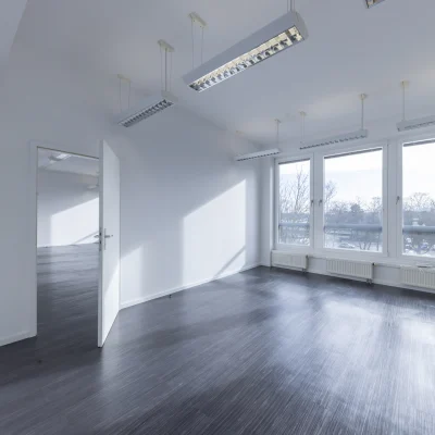 Bürofläche mit großzügigen Fensterfronten, viel Tageslicht und ruhiger Arbeitsatmosphäre.