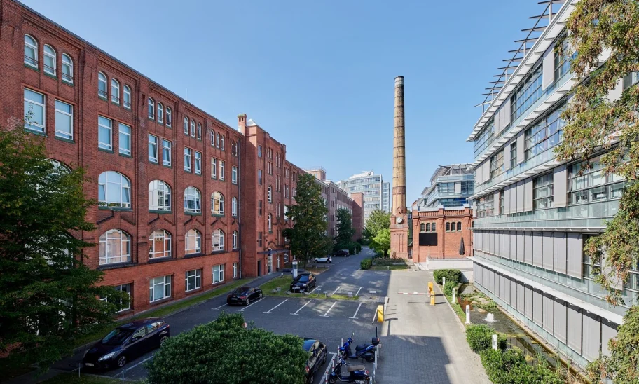 Außenansicht der Erlenhöfe Berlin mit denkmalgeschützter Backsteinarchitektur und modernen Bürogebäuden in urbanem Umfeld.