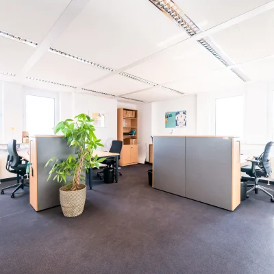 Helle Bürofläche mit strukturierten Arbeitsplätzen, modernen Trennwänden, Teppichboden und großen Fenstern für viel Tageslicht in der Karl-Wiechert-Allee 18–22 in Hannover.