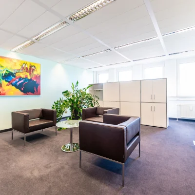 Konferenz- und Empfangsbereich mit moderner Beleuchtung, Empfangstresen und Sitzmöglichkeiten im Bürogebäude Karl-Wiechert-Allee 18–22 in Hannover.