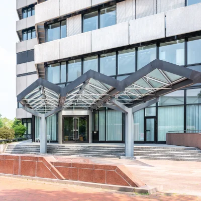 Repräsentativer Eingangsbereich des Bürogebäudes in der Karl-Wiechert-Allee in Hannover mit Glasüberdachung und großzügigem Vorplatz.