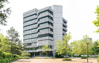 Außenansicht des Bürogebäudes in der Karl-Wiechert-Allee in Hannover mit markanter Architektur, mehreren Staffelgeschossen und grünem Umfeld.