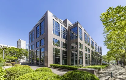 Eckansicht eines hochwertigen Bürogebäudes mit Natursteinfassade und großzügigen Fensterflächen an der Kaiserswerther Straße in Düsseldorf.