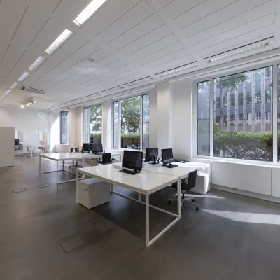 Helle Open-Space-Bürofläche mit großen Fensterfronten, modernen Arbeitsplätzen und strukturierter Deckenbeleuchtung im Bürogebäude an der Kaiserswerther Straße in Düsseldorf.