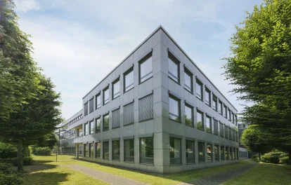 Moderne Außenansicht des Büroobjekts Nördlicher Zubringer in Düsseldorf mit klarer Fassadenstruktur, großen Fensterflächen und grüner Umgebung in ruhiger Lage.
