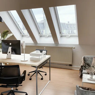 Visualisierte Dachgeschoss-Bürofläche mit mehreren Dachfenstern, hellem Bodenbelag und moderner Arbeitsplatzeinrichtung – Darstellung einer möglichen Bürogestaltung.