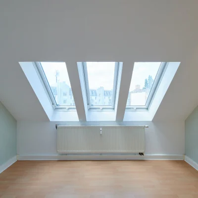 Leerstehendes Dachgeschossbüro mit Dachschrägen und Dachfenstern, das eine besondere Arbeitsatmosphäre bietet.