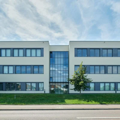Moderne Außenansicht des Bürogebäudes in der Raffineriestraße in Halle mit klarer Fassadengestaltung, großen Fensterflächen und gepflegtem Grünbereich.