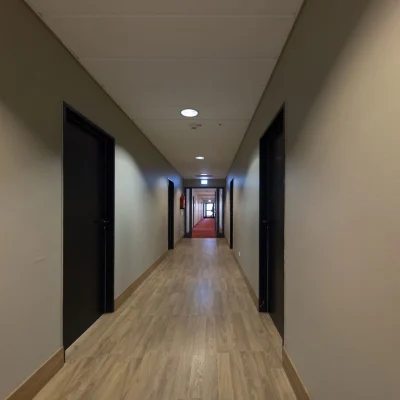 Innenflur mit Holzoptikboden, neutralen Wandfarben und geradliniger Wegeführung innerhalb der Büroetage.