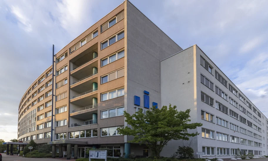 Eckansicht des TRIGA Bürocenters mit klarer Fassadengliederung, zurückspringenden Gebäudeteilen und urbanem Umfeld.