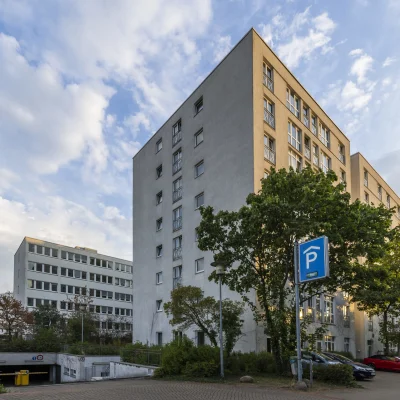 Seitliche Außenansicht des Bürogebäudes mit schlichter Fassadengestaltung und angrenzenden Grünflächen.