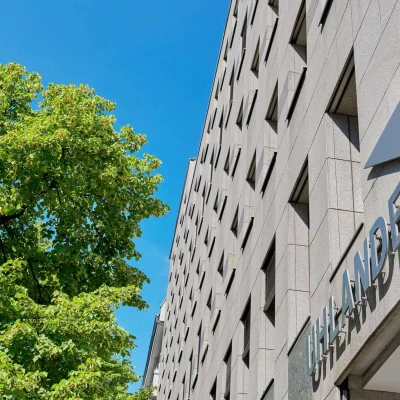 Fassadendetail des Uhlandeck in Berlin mit gut sichtbarem Gebäudenamen und klar strukturierter Natursteinfassade.