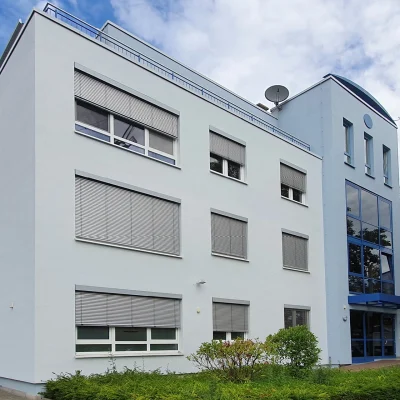 Ansicht des Eck-Gebäudes Kreuzberger Ring 68 in Wiesbaden mit blauer Fensterfront am Eingang.