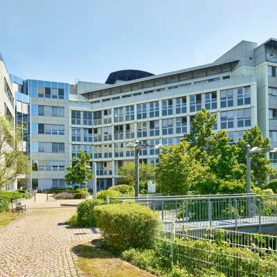 Eingangsbereich eines Bürogebäudes mit Treppe und Grünanlagen
