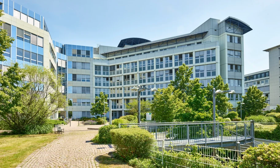 Eingangsbereich eines Bürogebäudes mit Treppe und Grünanlagen
