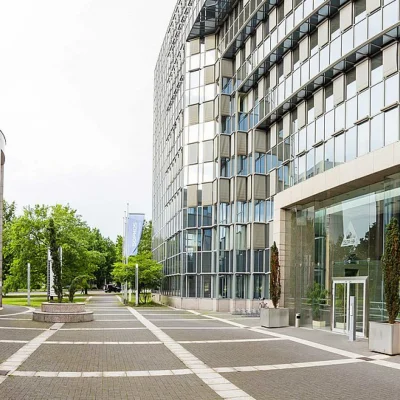 Eingangsbereich des Delta Haus in Wiesbaden mit moderner Architektur und gepflastertem Vorplatz.