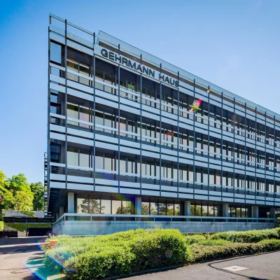 Bürogebäude Gehrmann Haus in Wiesbaden im Sommer mit grüner Umgebung und moderner Glasfassade