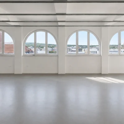 Leere Büroetage mit Rundbogenfenstern und Blick über die Dächer Stuttgarts