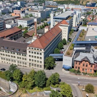 Luftaufnahme des Bürogebäude-Areals mit Leitz-Schriftzug und Weinbergen im Hintergrund