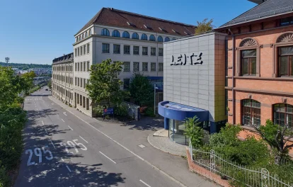 Straßenansicht mit Empfangsgebäude, Leitz-Schriftzug und historischer Klinkerfassade